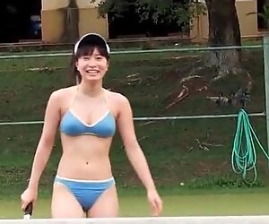 Japanische Schönheit spielt Bikini auf dem Tennisplatz